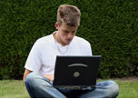 man with laptop on grass
